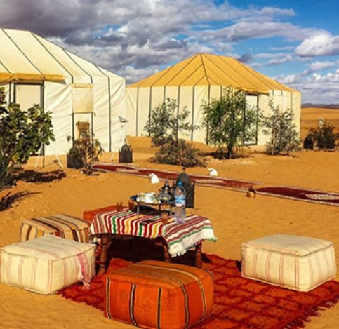 Luxury desert camp tents at sunset in the Moroccan Sahara