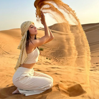 Travelers enjoying a desert tour riding camels and exploring the sand dunes