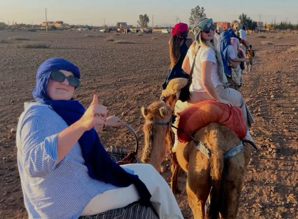 Traveler riding a camel during a two-day trek in the Erg Chebbi desert